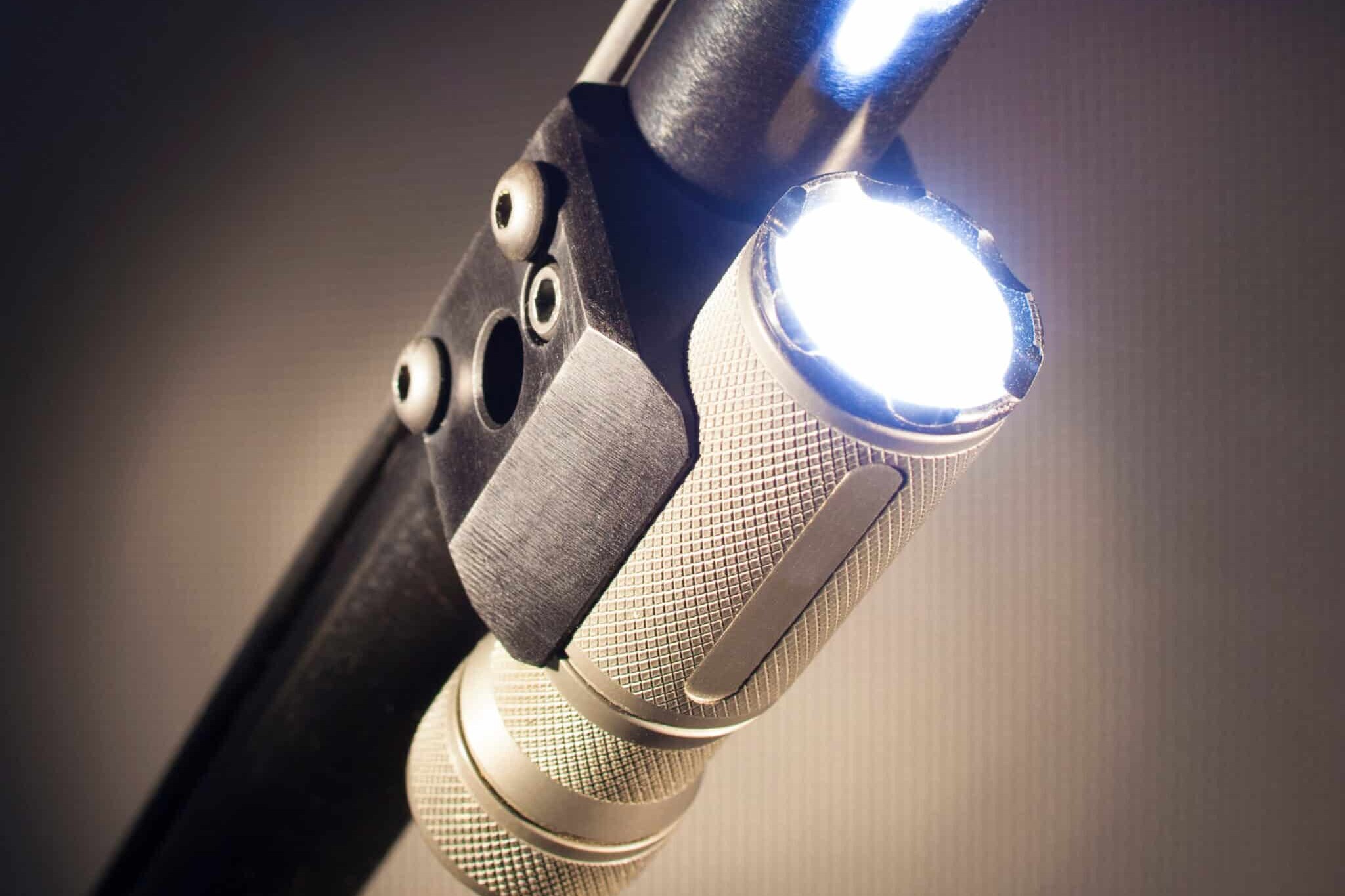 Flashlight mounted an running under a shotgun barrel